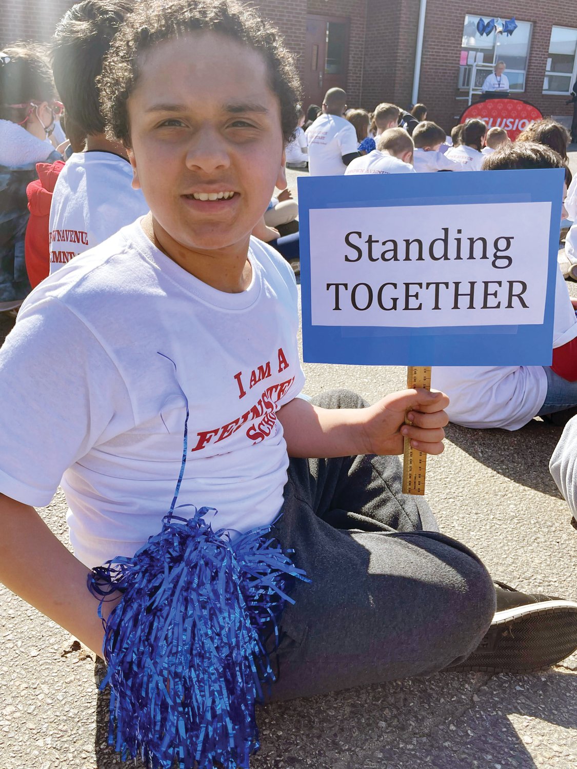UNITED WE STAND: Fourth-grader Kenny Davila holds a sign declaring Brown Avenue’s students are “Standing Together.”